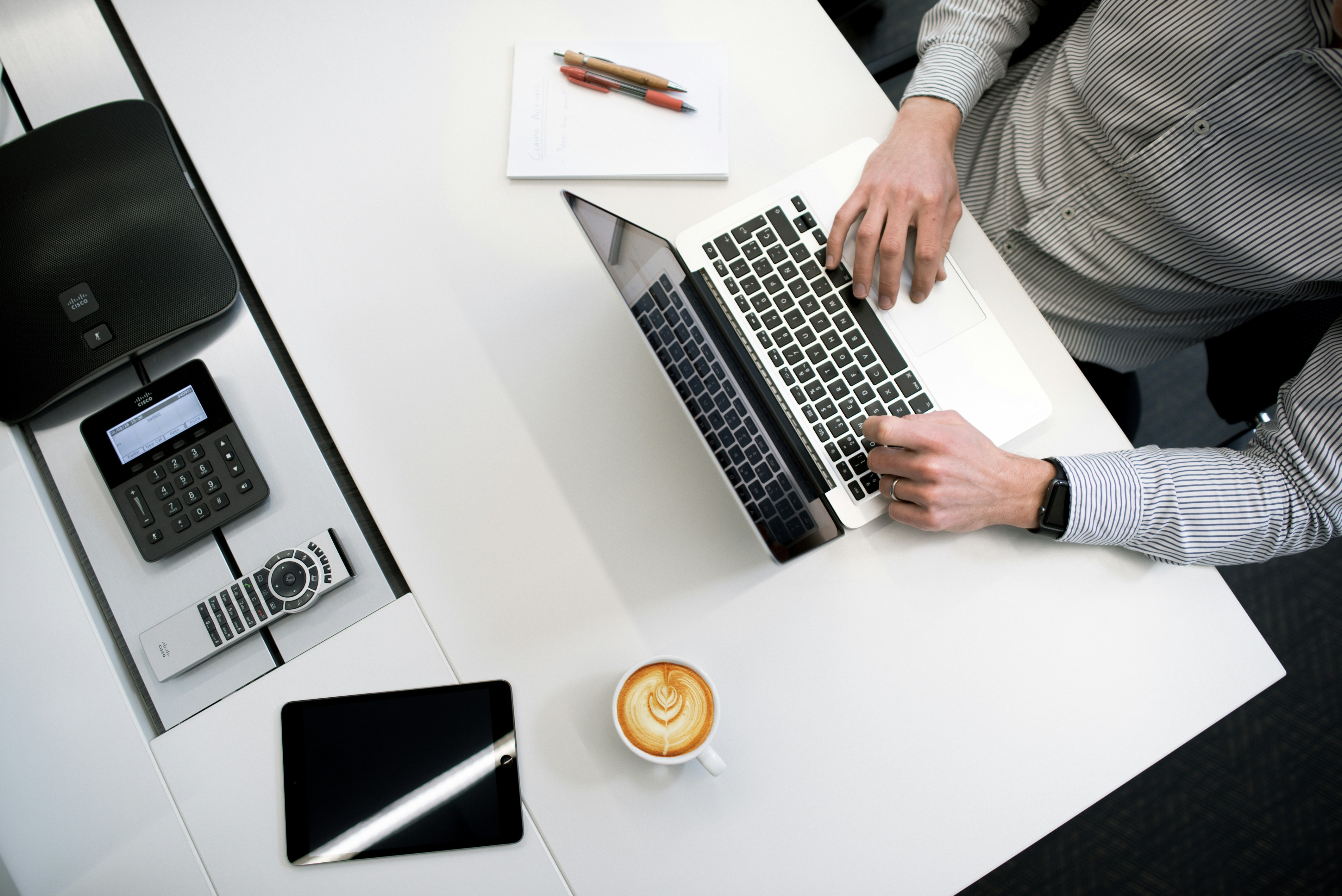 Image from above of a person typing on a laptop keyboard